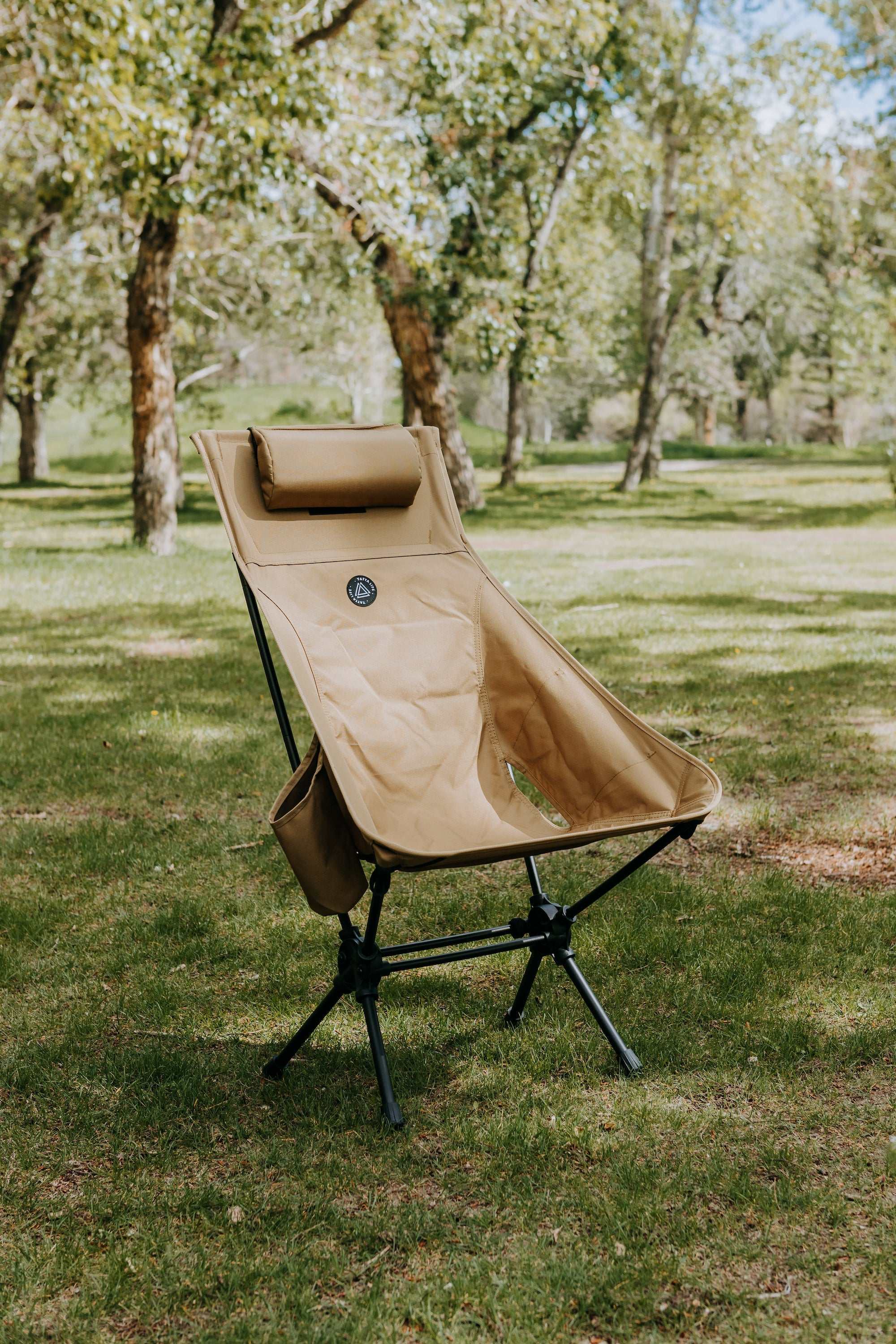 High back ultralight folding camping chair with storage pouch in outdoor setting.